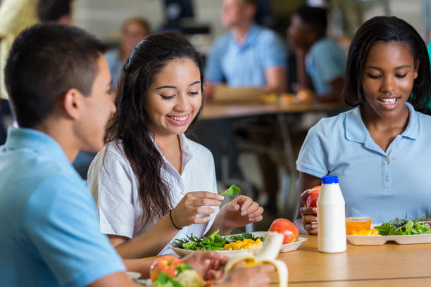 children sitting at a lunch table at school.